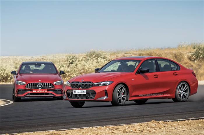 Two red German sports cars racing on a track.